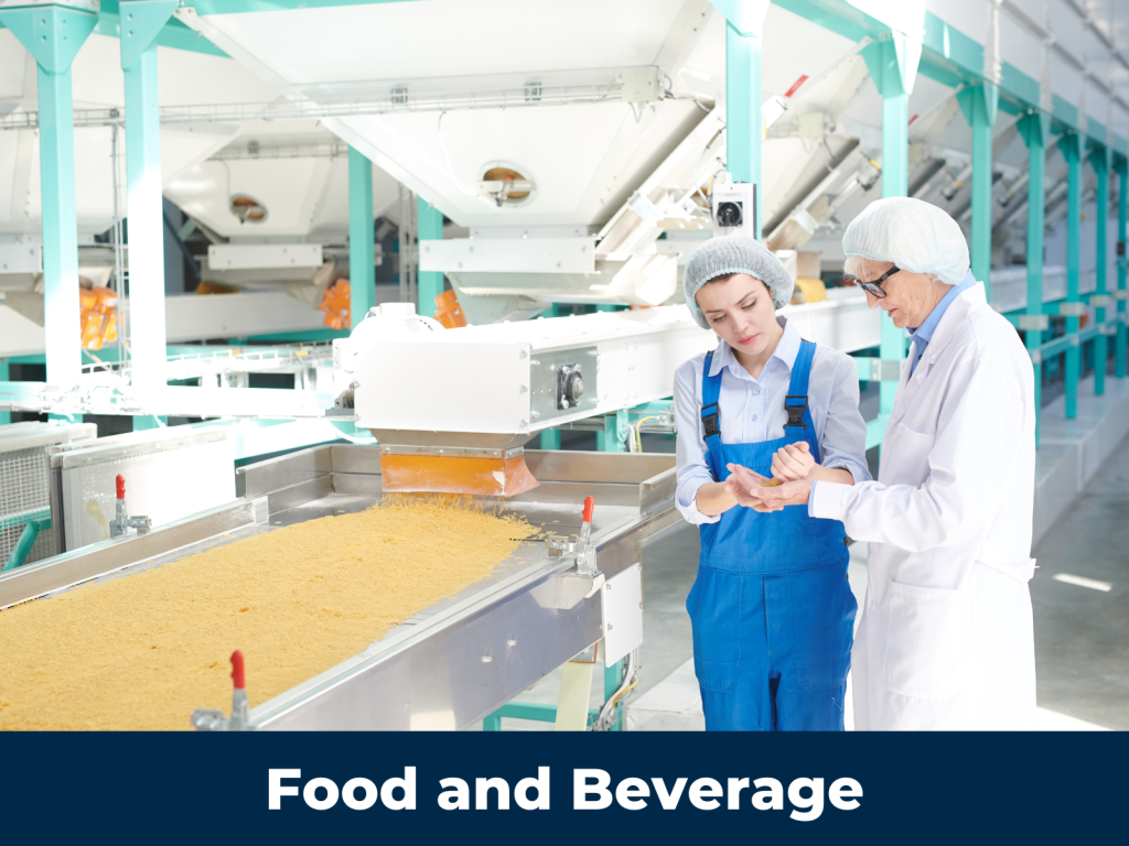 Two food production workers operate a mass production device.
