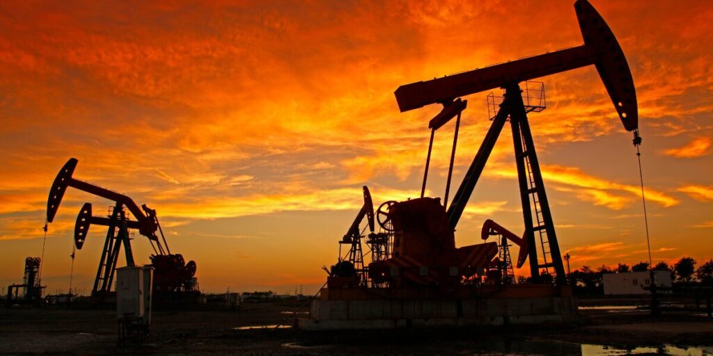 Oil pumpjacks silhouetted against an orange sunset