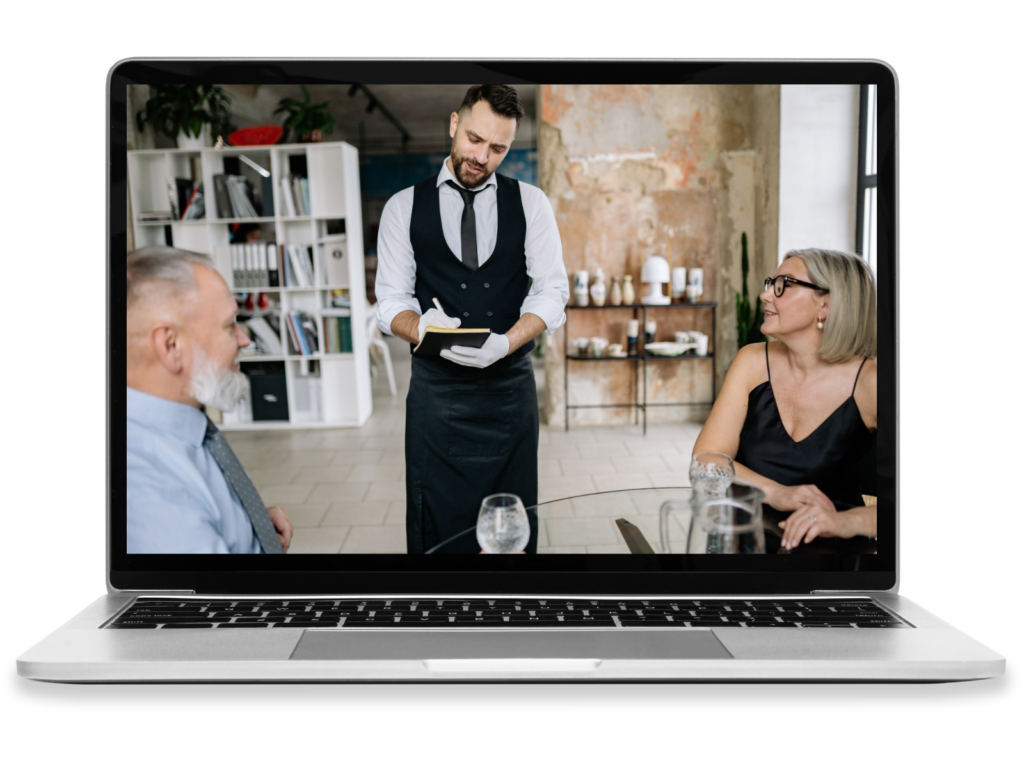 A laptop showing a waiter serving a couple.