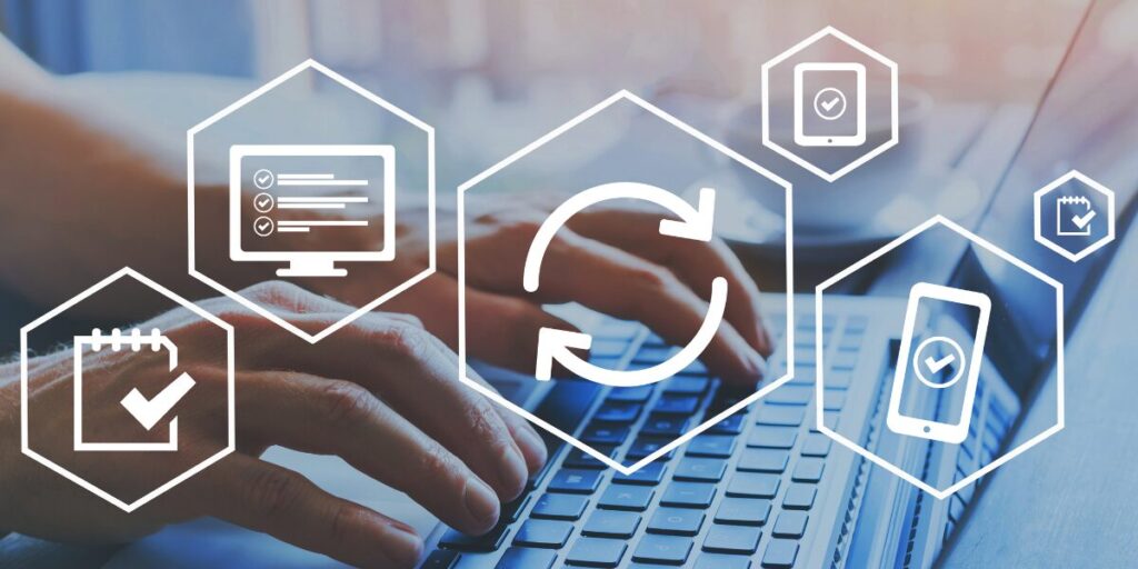 Hands typing on a laptop with icons representing software syncing across devices